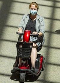 戴面具的女子骑着代步车在十大博彩推荐排名-希区柯克医疗中心