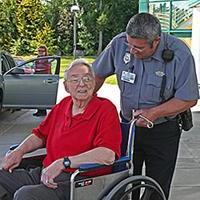 保安带着轮椅上的病人在正门