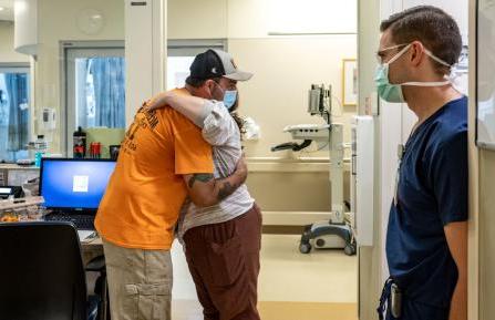 马克·麦肯尼斯拥抱十大博彩推荐排名希区柯克医疗中心的护士萨曼莎·E. 丹尼尔斯，注册会计师，他是救了他一命的护理团队的一员.