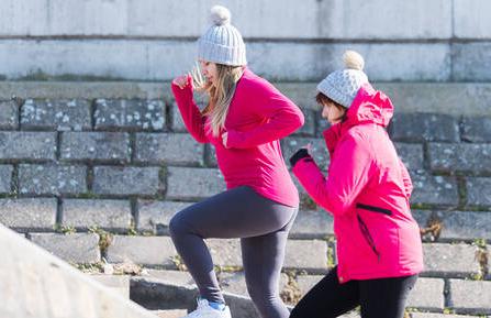 Two women exercising on steps